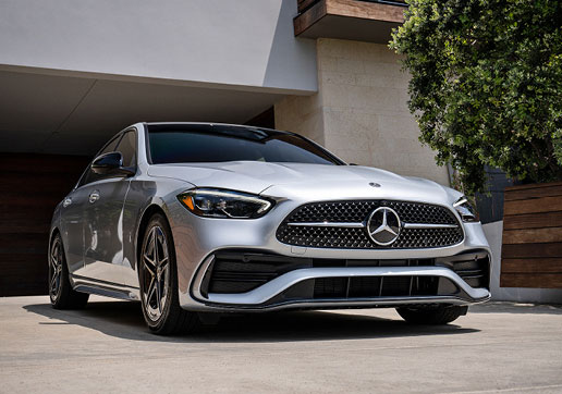 Silver Mercedes-Benz C-Class sedan parked outside a modern home