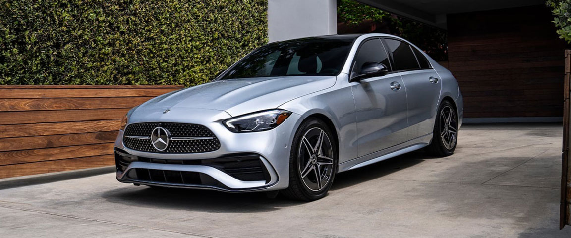 Silver Mercedes-Benz C-Class sedan parked in a residential driveway