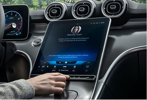 Driver using the Mercedes-Benz MBUX touchscreen infotainment system with personalized settings