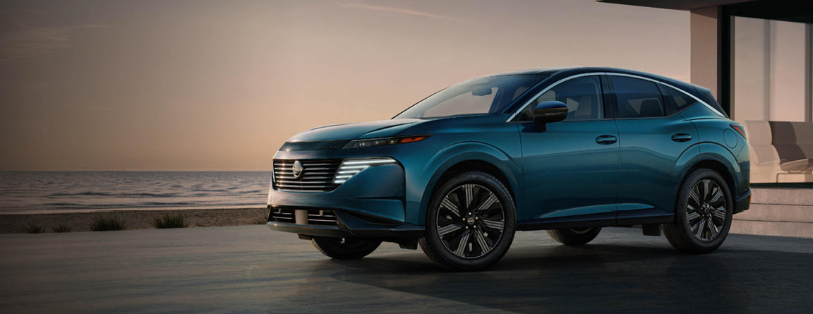 Blue Nissan Murano SUV parked by a modern waterfront home