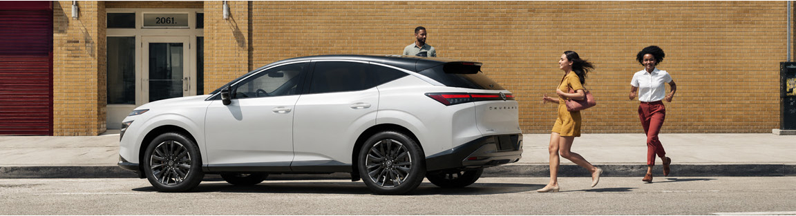 White Nissan Murano parked on a city street with pedestrians
