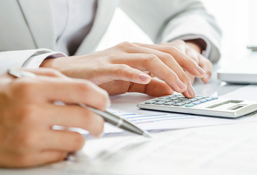 Customer calculating vehicle financing costs with paperwork and a calculator