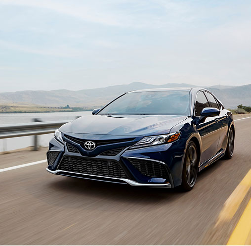 Blue Toyota Camry driving on a scenic highway