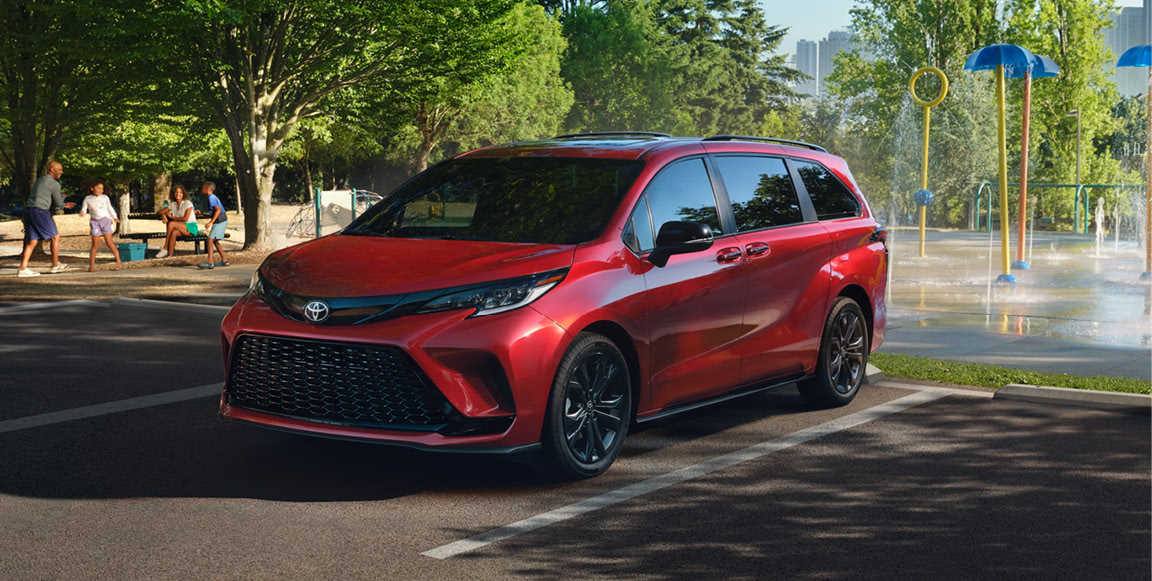 Red Toyota Sienna parked beside a splash pad and park highlighting family-friendly versatility and everyday convenience.