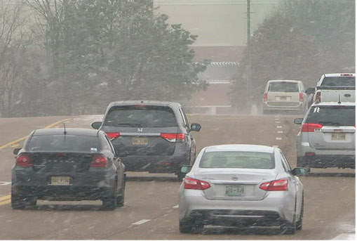 Vehicles driving during snowy weather conditions illustrating challenging winter driving and road safety.