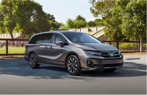 Honda Odyssey minivan parked near a neighborhood park highlighting family transportation and modern exterior styling.