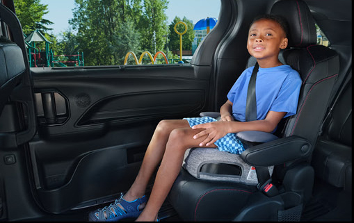 Child secured in a child safety seat inside the Toyota Sienna showcasing spacious rear seating and family-focused safety.