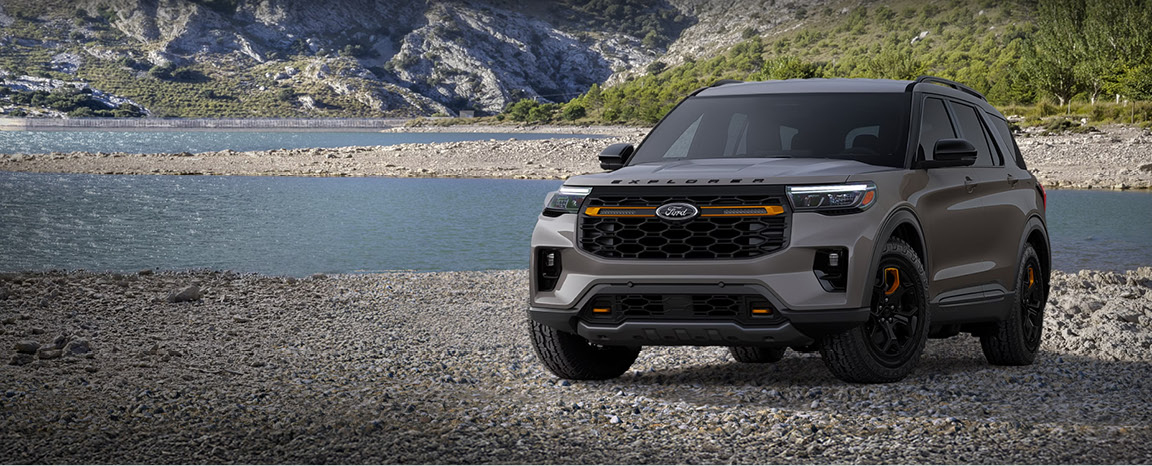 Ford Explorer Tremor SUV parked beside a mountain lake highlighting rugged off-road styling and outdoor adventure capability.