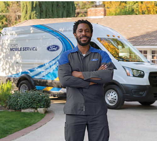 Ford Mobile Service technician standing in front of a Ford Mobile Service van providing convenient vehicle maintenance at a customer's home.