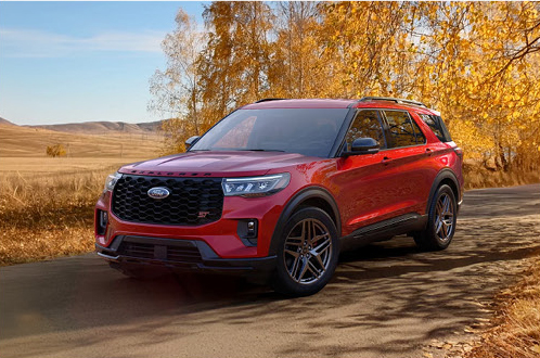 Red Ford Explorer ST SUV parked on a scenic country road highlighting sporty performance and bold exterior styling.