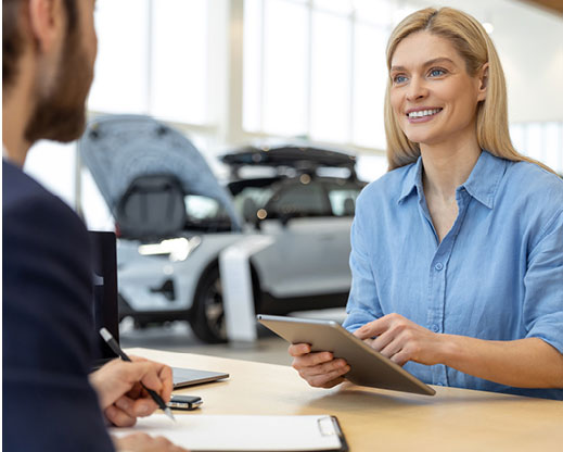 Woman smiling at dealer holding tablet