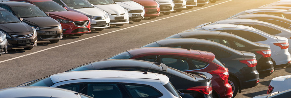 Rows of new and used cars and SUVs displayed for sale on an auto dealership lot