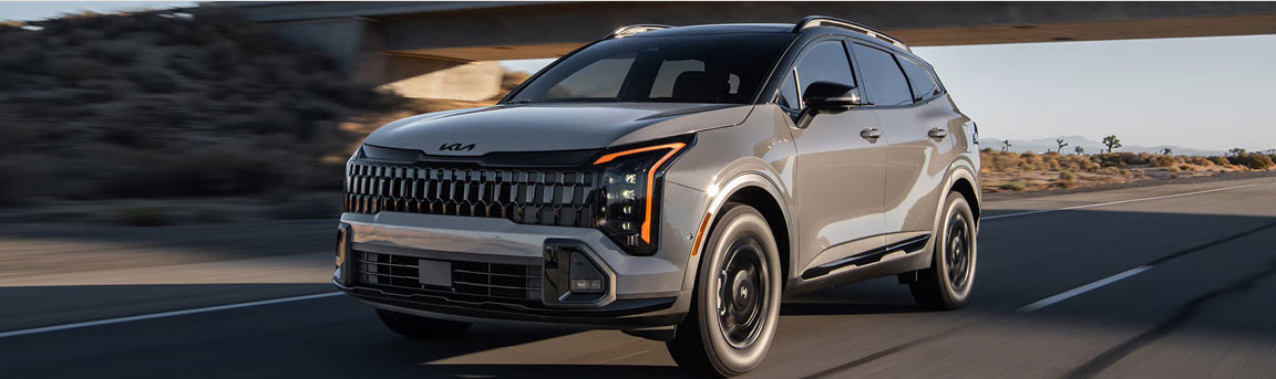 Kia Sportage compact SUV driving on a highway through a desert landscape
