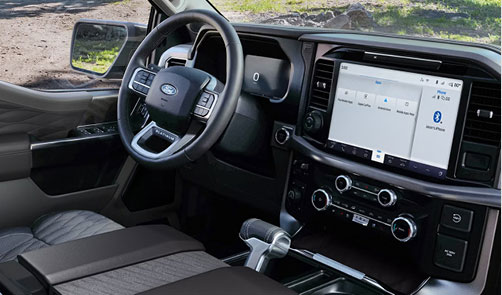 Ford F-150 interior with digital instrument cluster, large touchscreen infotainment system, and center console