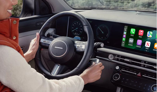 Driver using the infotainment system with Apple CarPlay inside a modern Hyundai vehicle