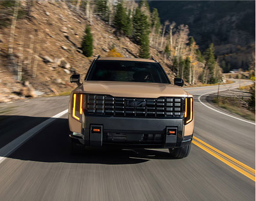 Kia Telluride three-row SUV driving on a winding mountain road