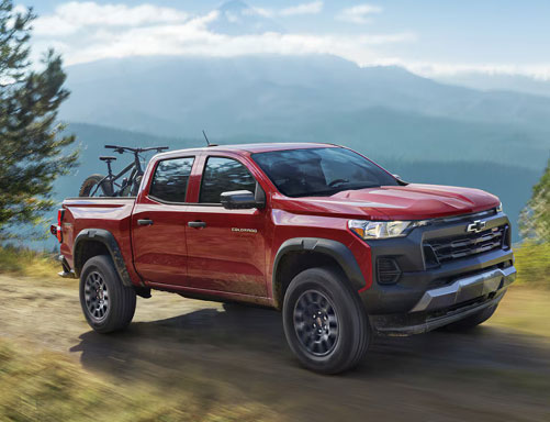 Chevrolet Colorado truck with bike in bed on mountain road