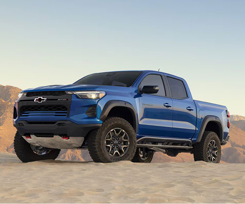 Blue Chevrolet Colorado ZR2 truck driving on desert sand