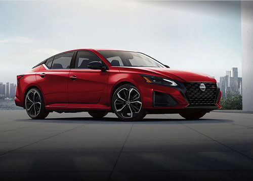 Red Nissan Altima sedan parked on rooftop with city skyline