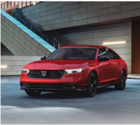 Red Honda Accord sedan parked near glass building