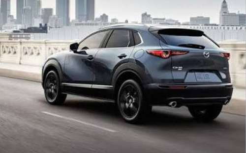 Mazda CX-30 driving through the city with rear three-quarter view