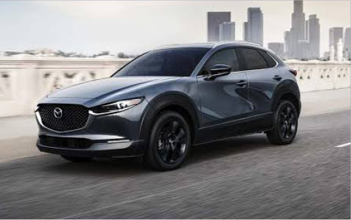 Dark gray Mazda CX-30 driving on a city road