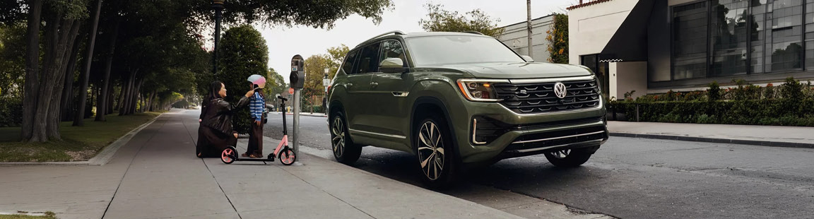 Volkswagen Atlas SUV parked curbside while a family prepares for a neighborhood outing.