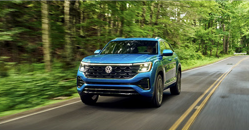FILE 15: Volkswagen Taos compact SUV driving on a tree-lined road through a forest.