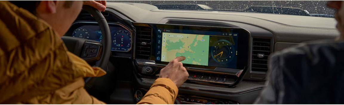 Chevrolet Silverado interior with driver using touchscreen navigation system