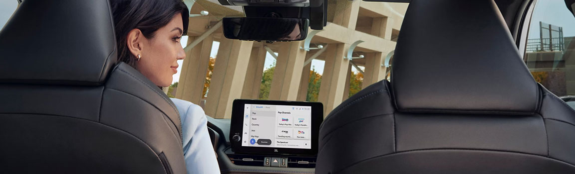 Rear passenger using the infotainment touchscreen inside a Honda CR-V
