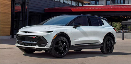 White Chevrolet Equinox EV parked outside a modern building