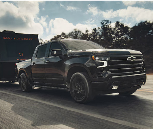 Black truck towing trailer